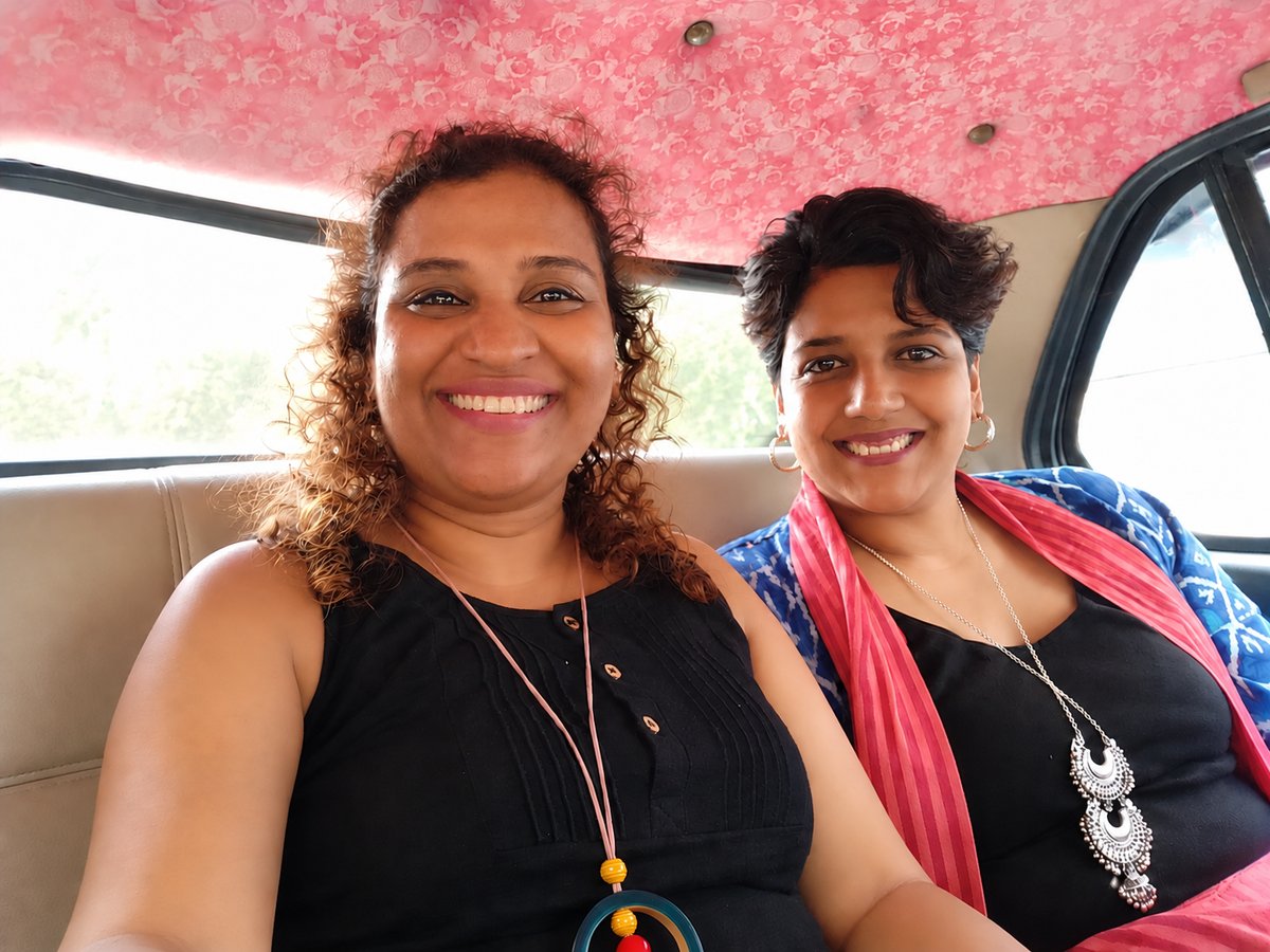 Radha Rangarajan and Suchi Govindarajan smiling together in the back seat of a car